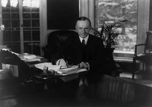 Calvin Coolidge am Schreibtisch, by National Photo Company [Public domain]
