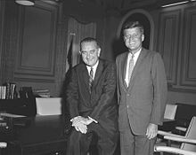 Präsident John F. Kennedy (rechts stehend) mit Vizepräsident Lyndon B. Johnson
